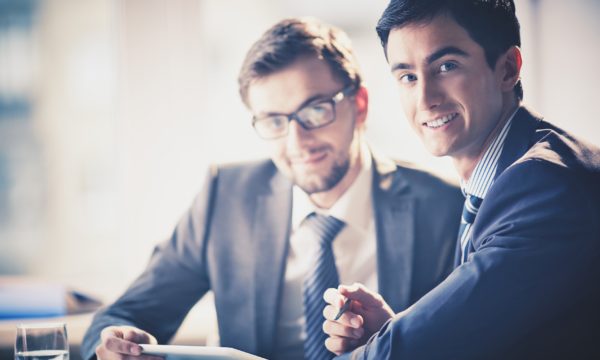 Image of smart young businessmen looking at camera at meeting